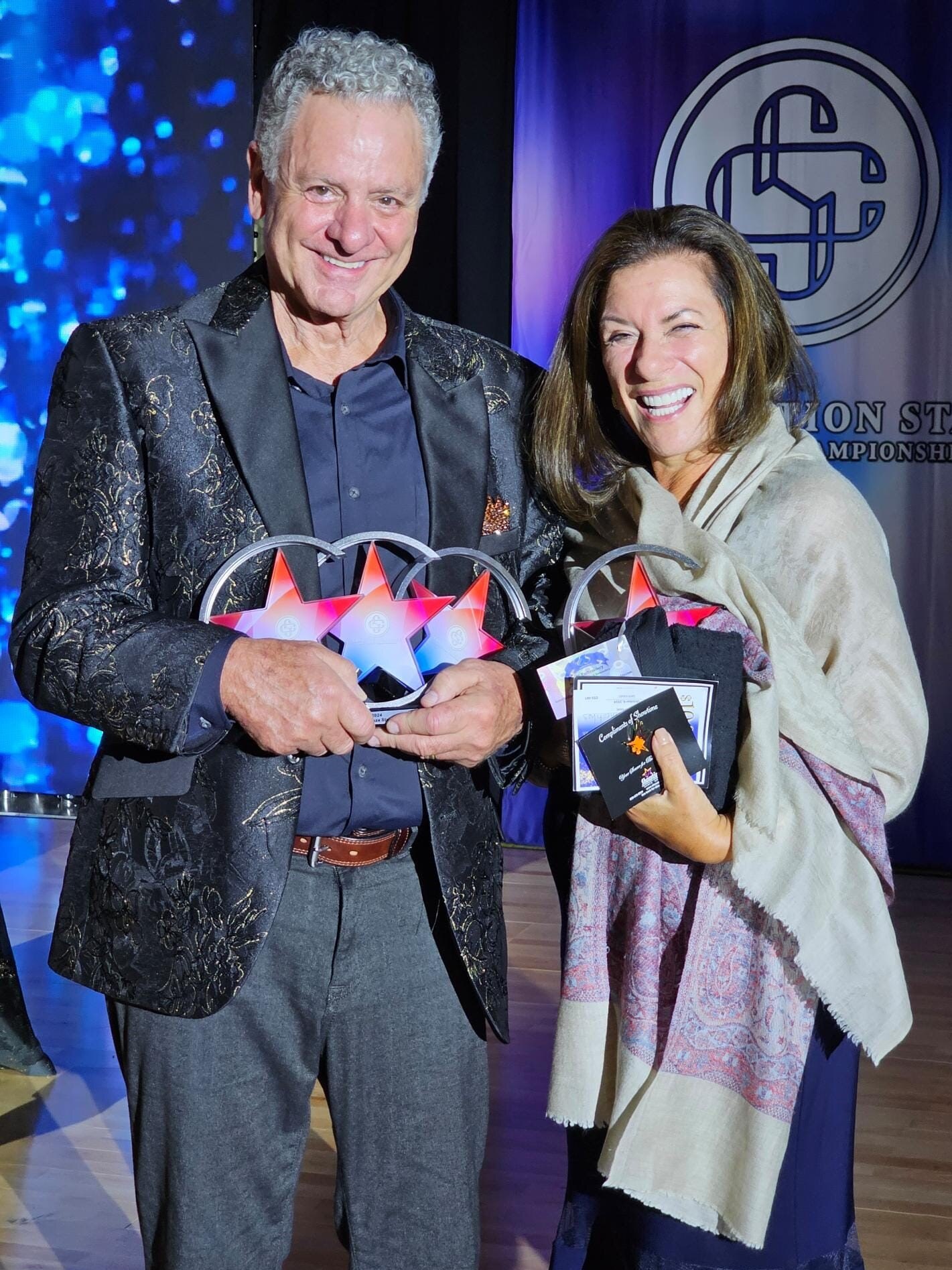 2 persons holding trophies